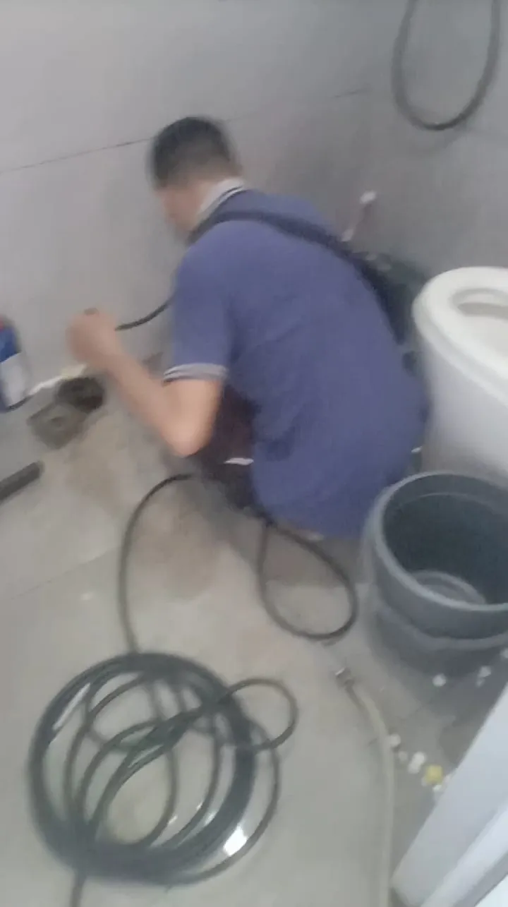 Petugas membersihkan saluran WC di kamar mandi