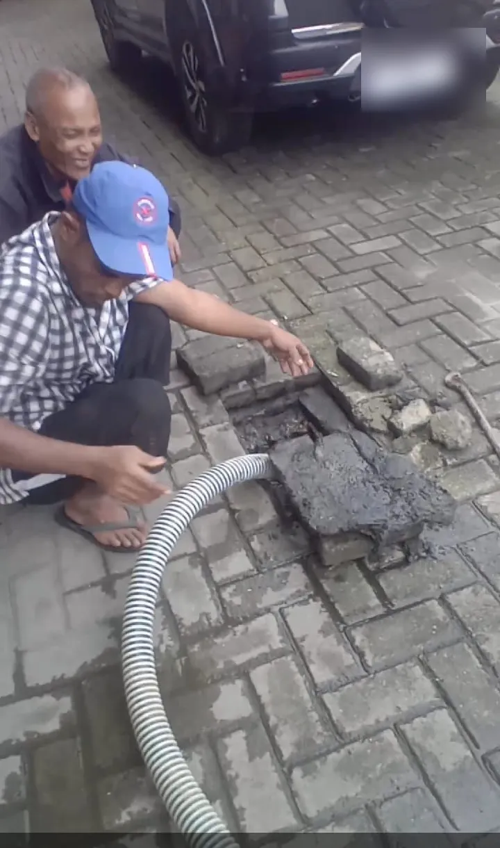 Tim membuka penutup got di halaman berpaving