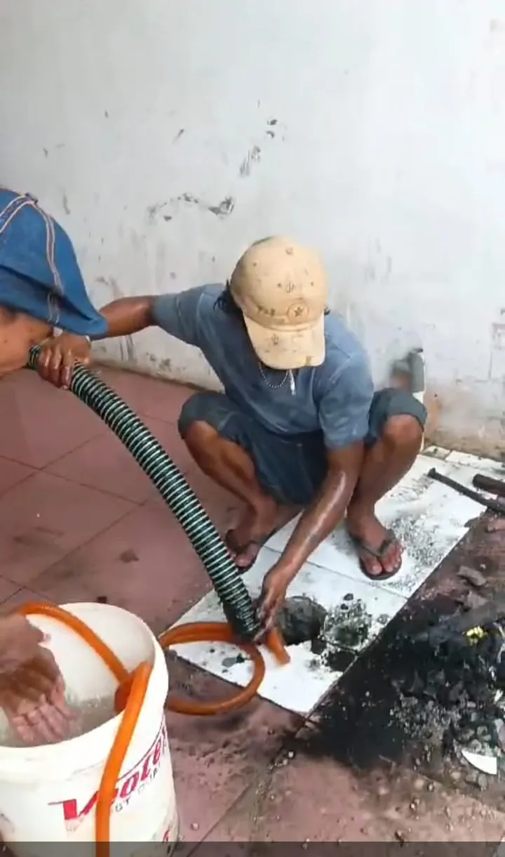 Petugas membersihkan saluran dengan selang sedot